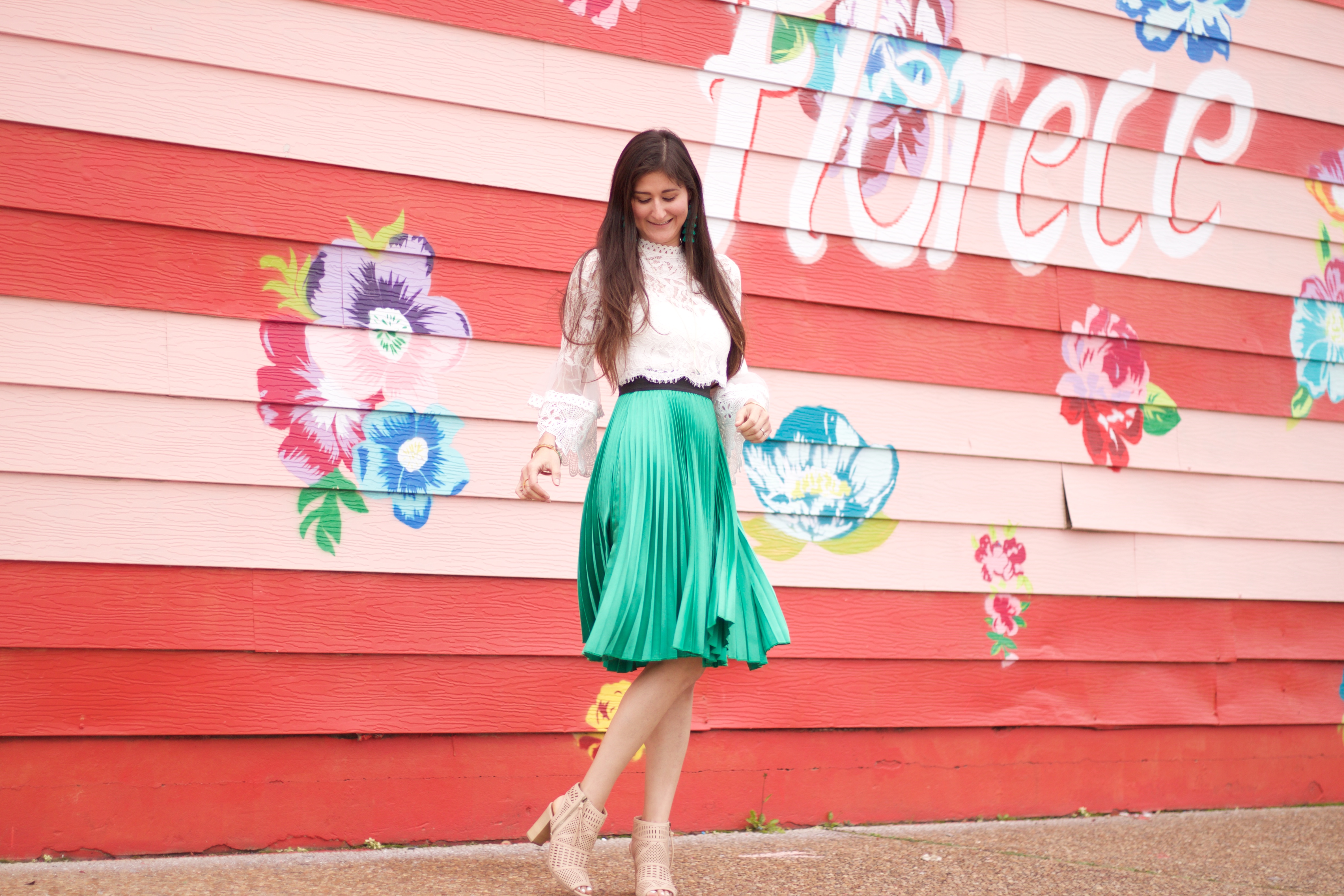 Houston blogger Jenni Metz is modeling a green pleated skirt and lace crop top