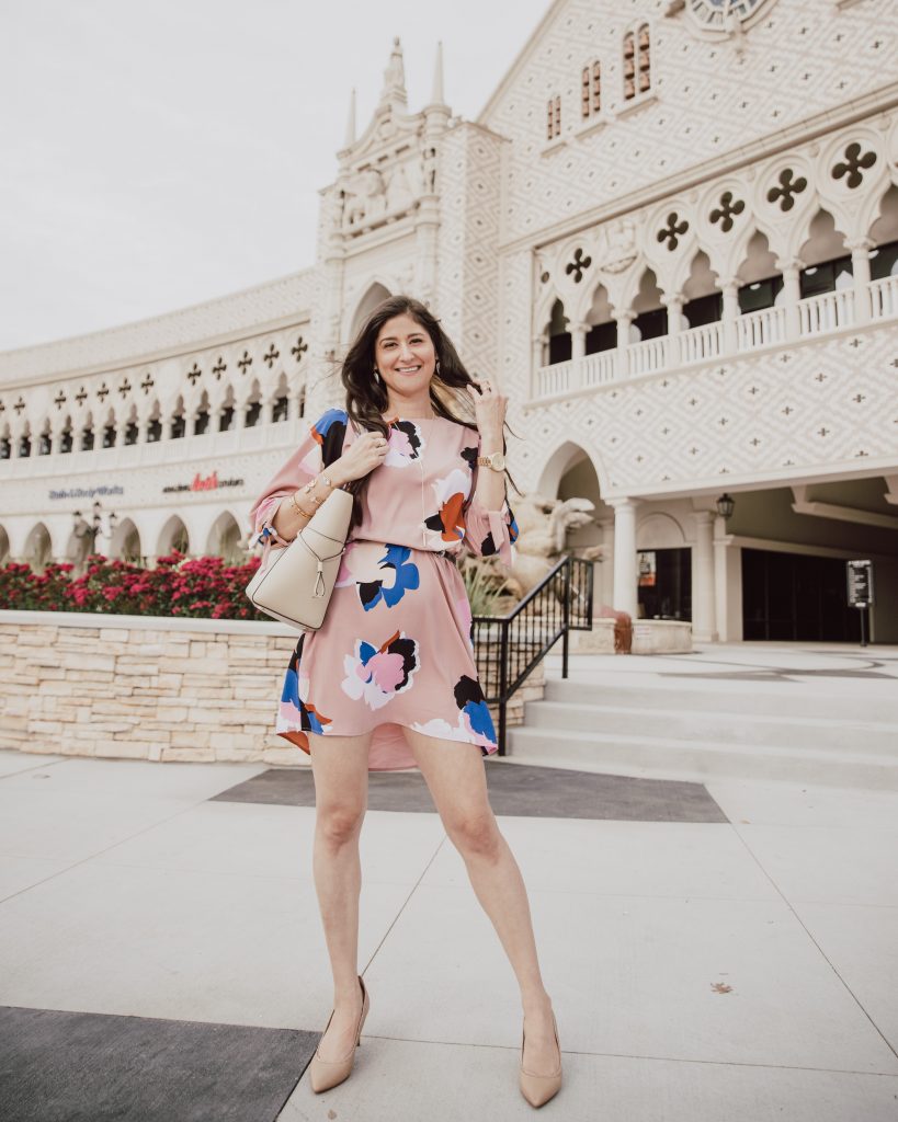 Top fashion blogger Jenni Metz wears a Blush pink floral dress styled a different way. Click to see the original dress. Spring style is here and floral print is now in session. #floralprintdress #mididresses #Easterdresses