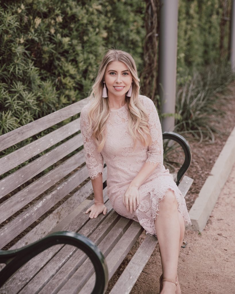 Blogger is wearing a blush pink body con dress. 3/4 sleeves with eyelash lace hem. Midi dress great for spring wedding and Easter. See more at thefashionablemaven.com