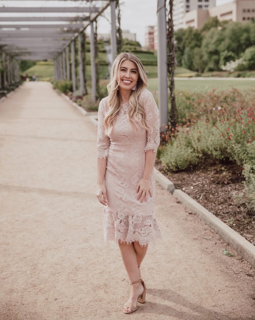 Blogger is wearing a blush pink body con dress. 3/4 sleeves with eyelash lace hem. Midi dress great for spring wedding and Easter. See more at thefashionablemaven.com