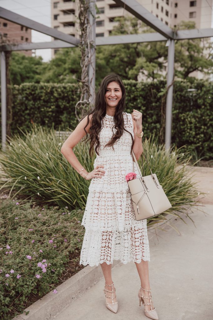 The blogger Jenni is wearing an elegant sleeveless crochet dress in white. Nude pumps with stud embellishments. Valentino rock stud dupe shoes. 