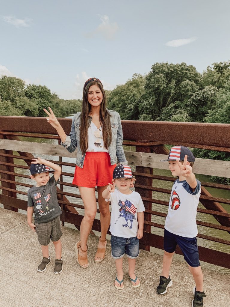 Blogger from The Fashionable Maven: Jenni Metz is wearing red shorts, white cami, denim jacket and striped headband. Her 3 sons are dressed in their 4th of July outfit. Amazon Fashion, Amazon finds.