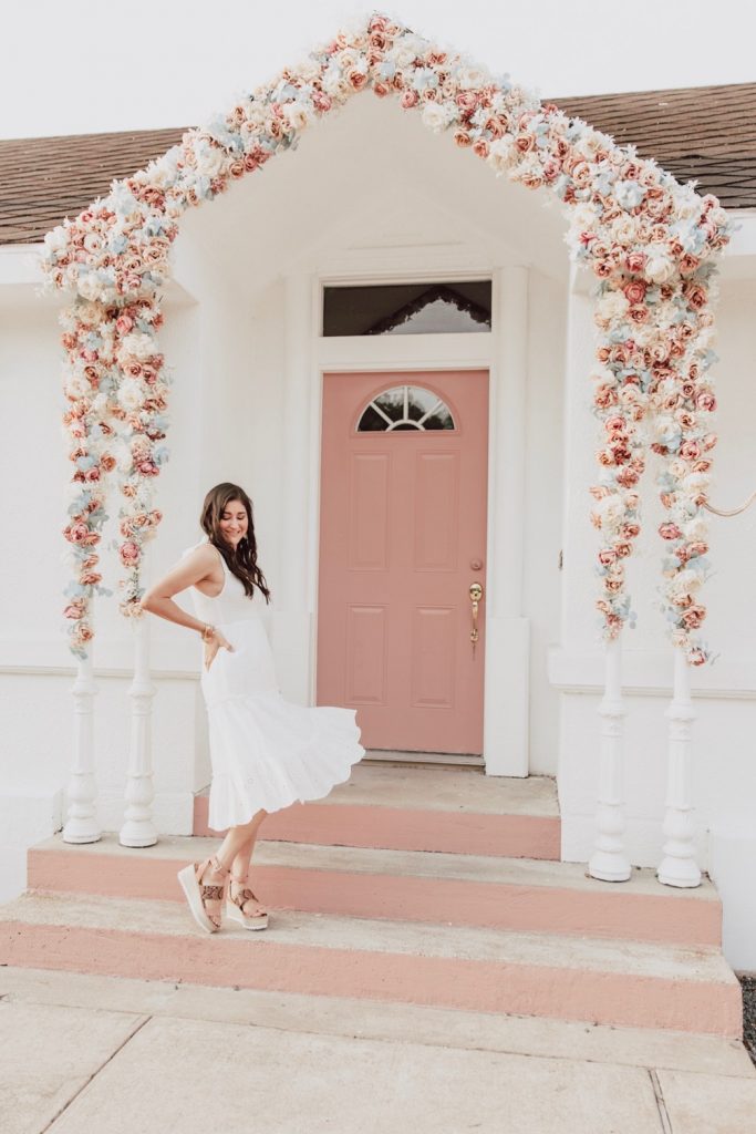 Blogger Jenni Metz is wearing a white eyelet dress from Chicwish. 