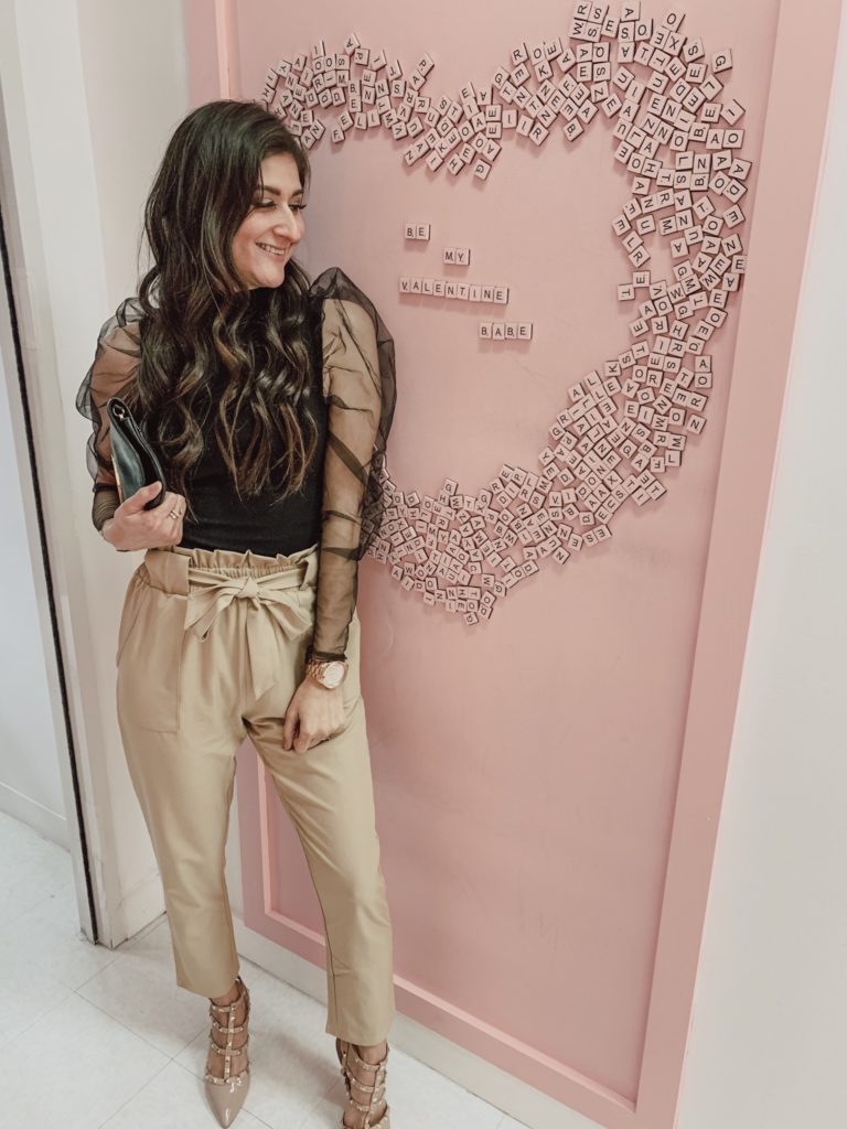 Valentines day outfits from The Fashionable Maven: Jenni Metzler wearing tan paperbag pants and black puff sleeve shirt.
