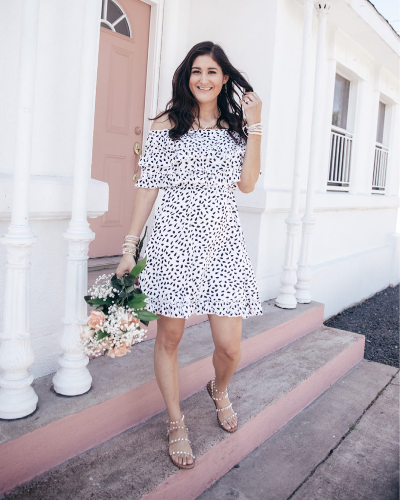 Jenni Metzler from The Fashionable Maven is wearing a white and black dot off the shoulder dress from Amazon. 